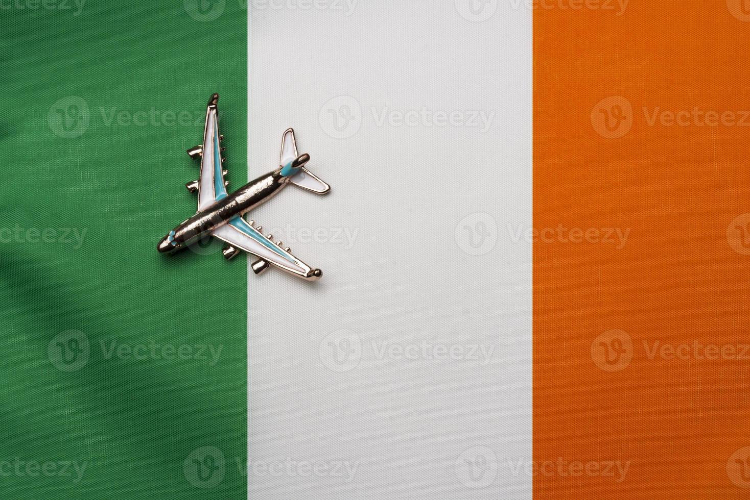 avión sobre el concepto de viaje de la bandera de irlanda. avión de juguete en una bandera. foto