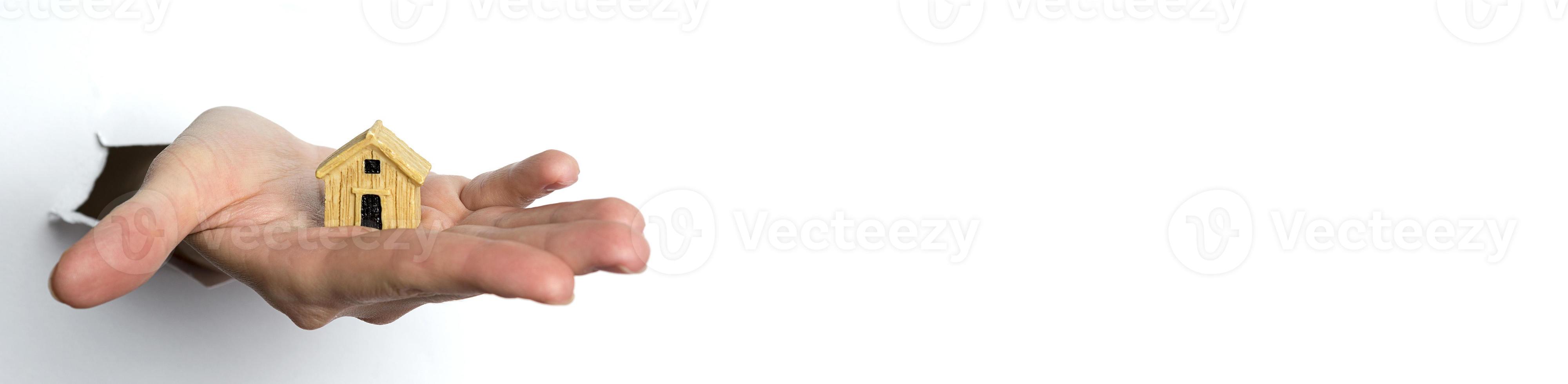 Female hand holding a house on a white background.Copy Space. photo