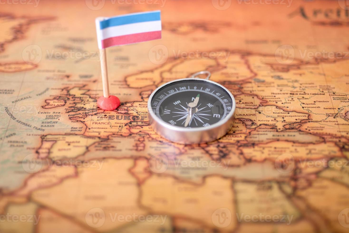 Luxembourg flag and compass on the world map. photo