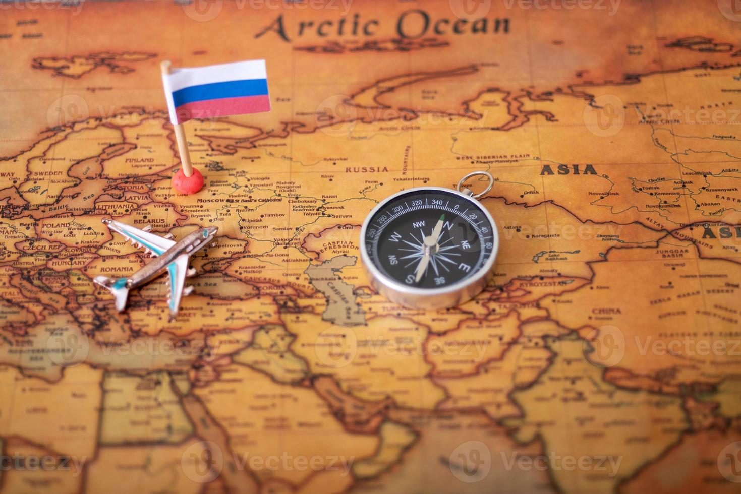 The flag of Russia on the world map with an airplane and a compass. photo
