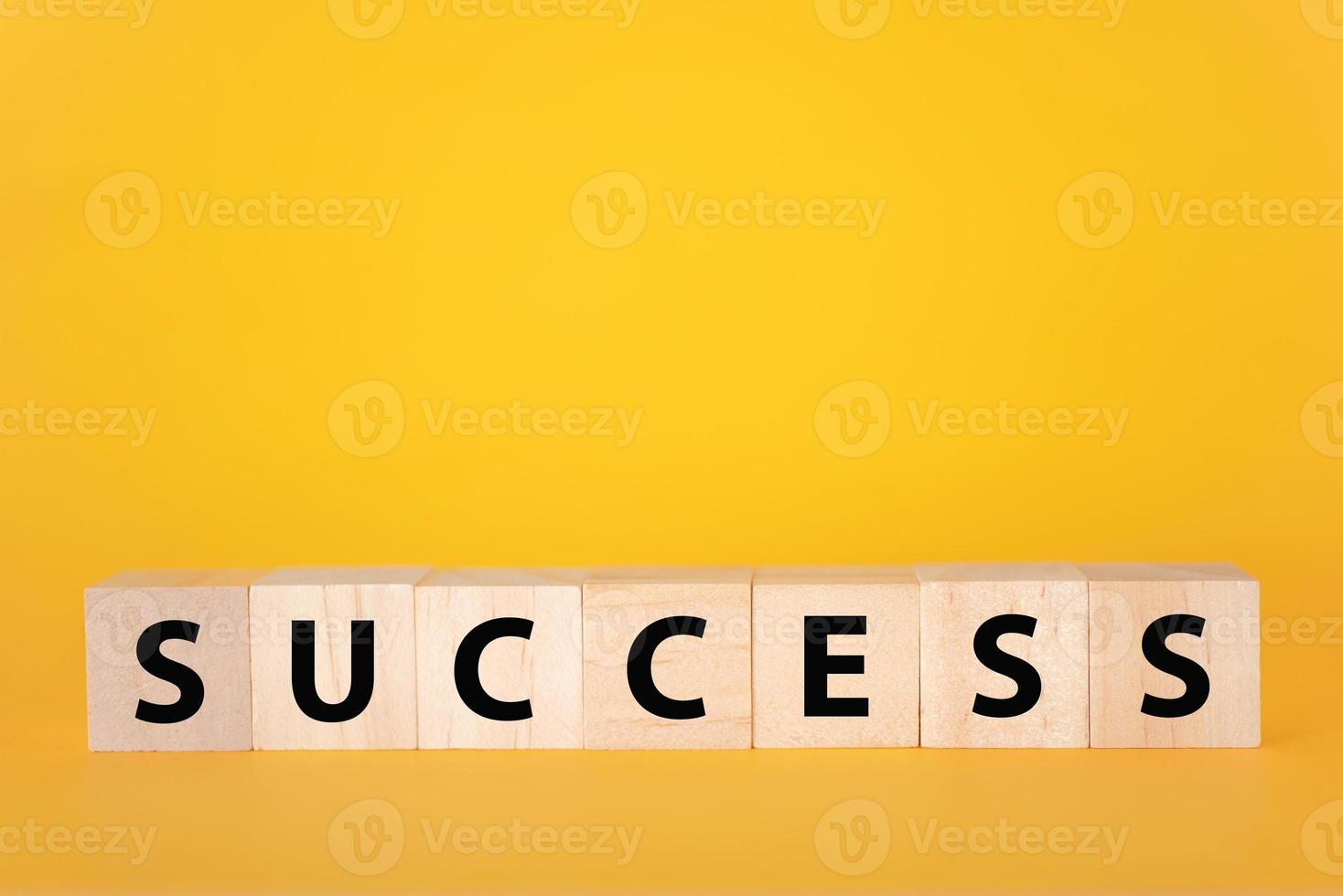 The success of the text on a yellow background of wooden cubes. photo