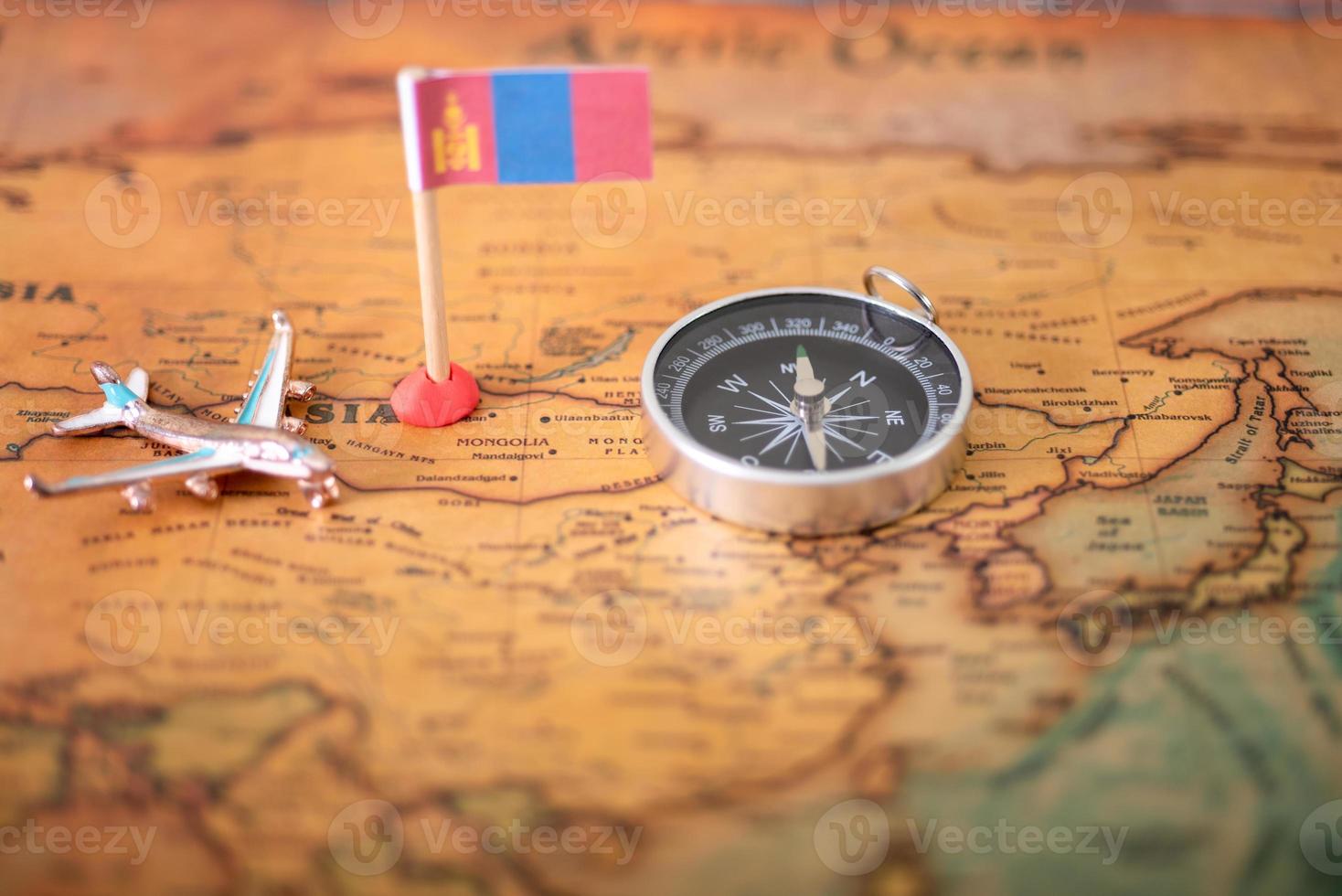 Flag of Mongolia, airplane and compass on the world map. photo