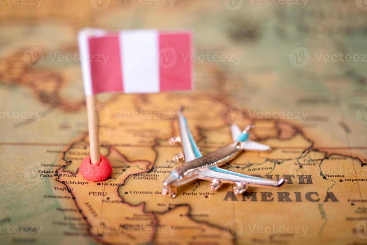 la bandera de Perú y el avión en el mapa mundial. foto