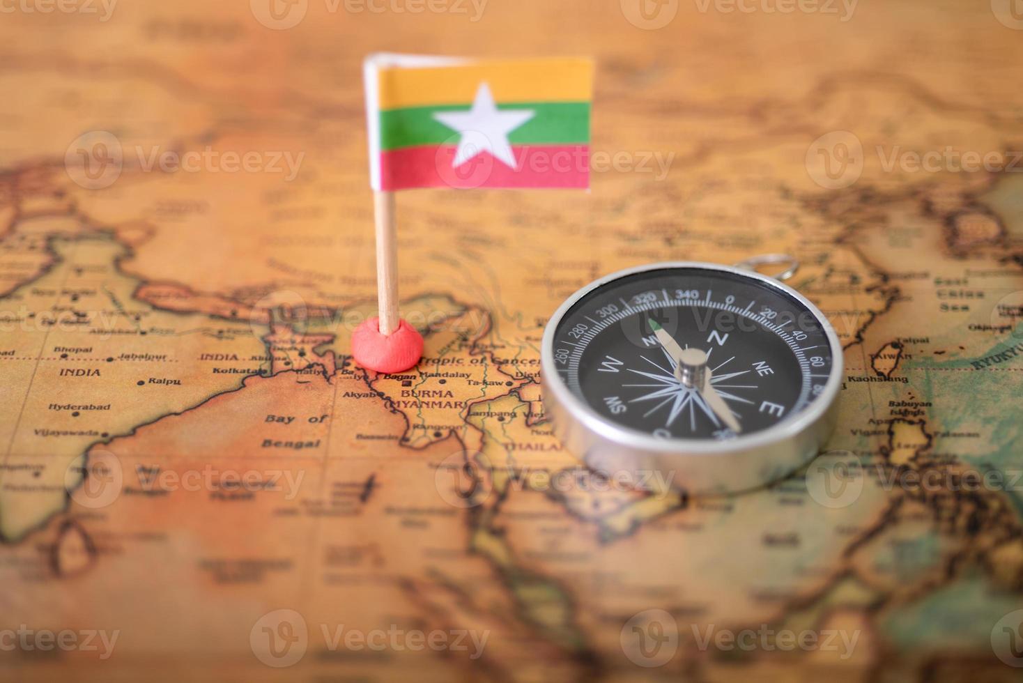 bandera de myanmar y brújula en el mapa mundial. foto