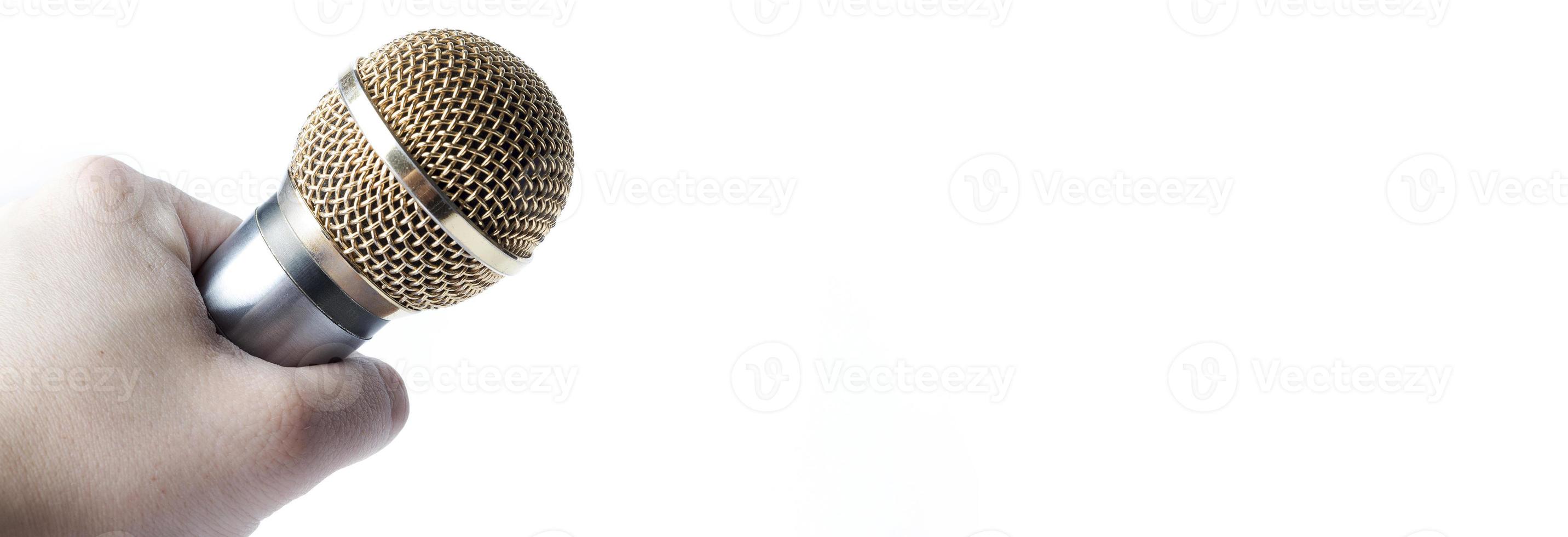 A man's hand holds a microphone on a white background. Copy Space. photo