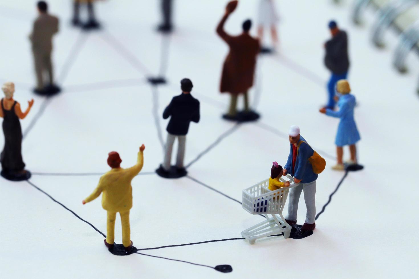 close up of miniature people with social network diagram on open notebook on wooden desk as social media concept photo