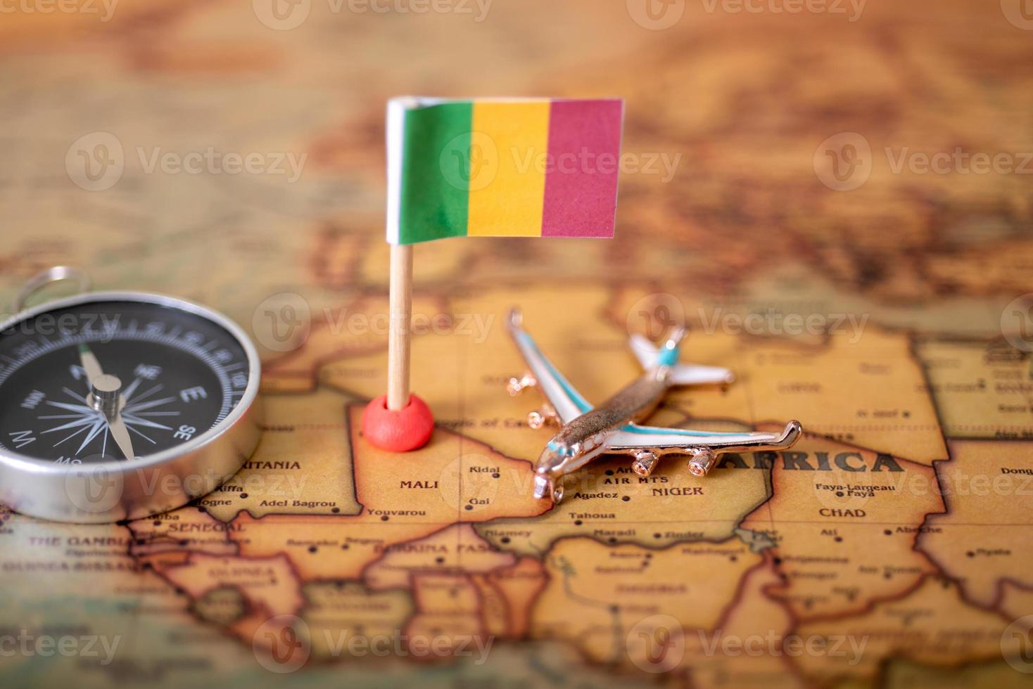 Flag of Mali, plane and compass on the world map. photo