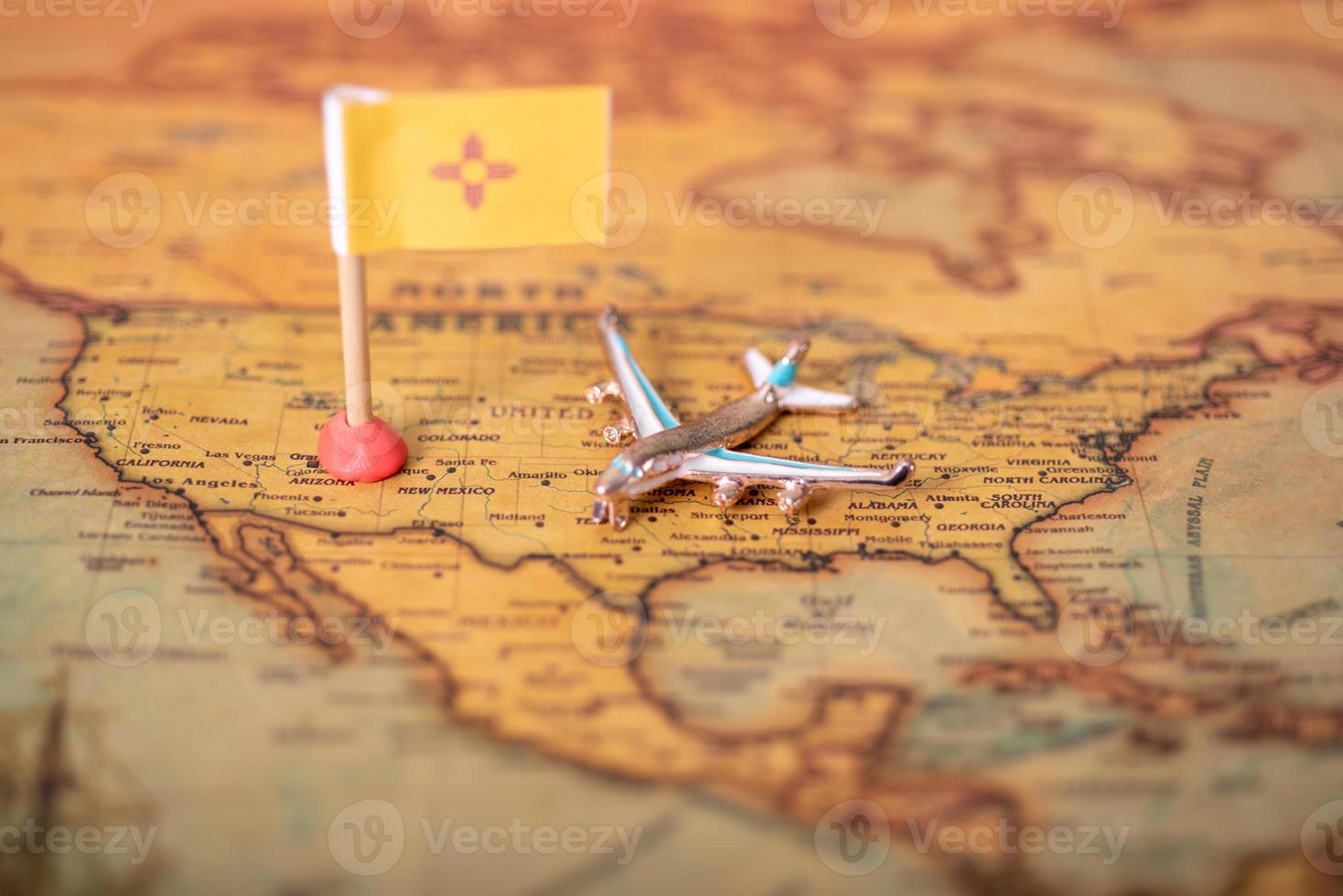 The flag of New Mexico and the plane of the old world map. photo