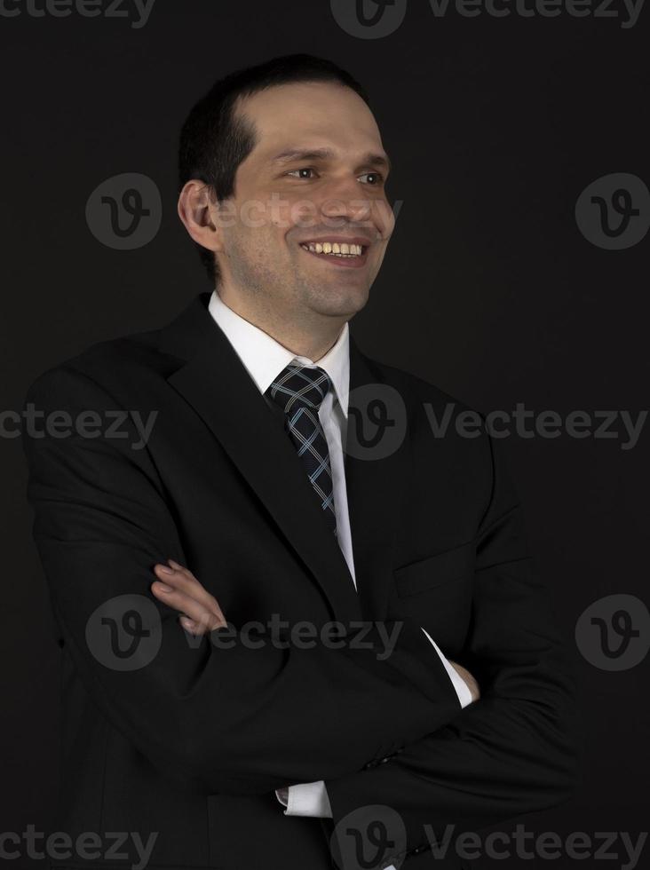 A man in a black suit on a black background. photo