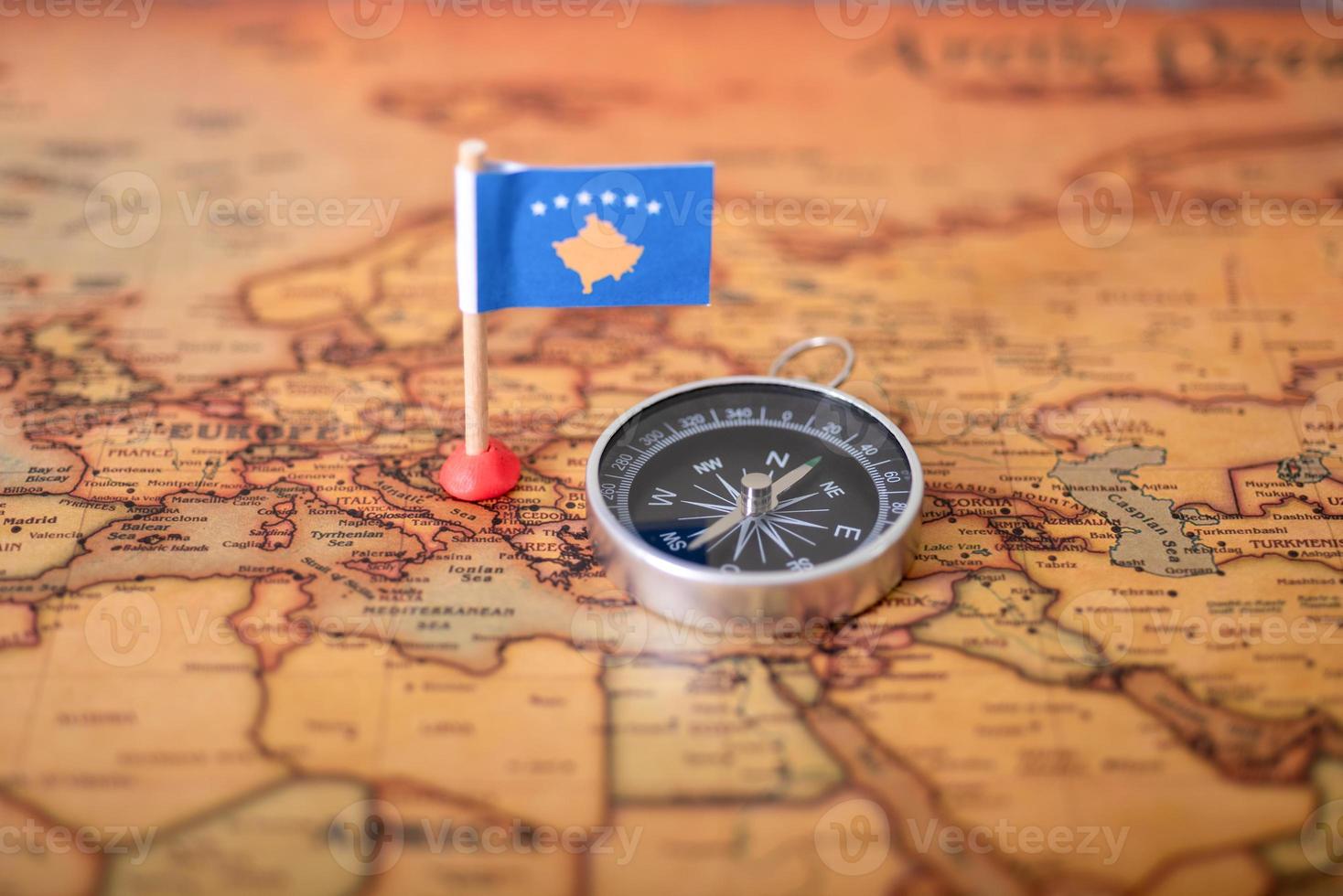 Flag of Kosovo and compass on the world map. photo