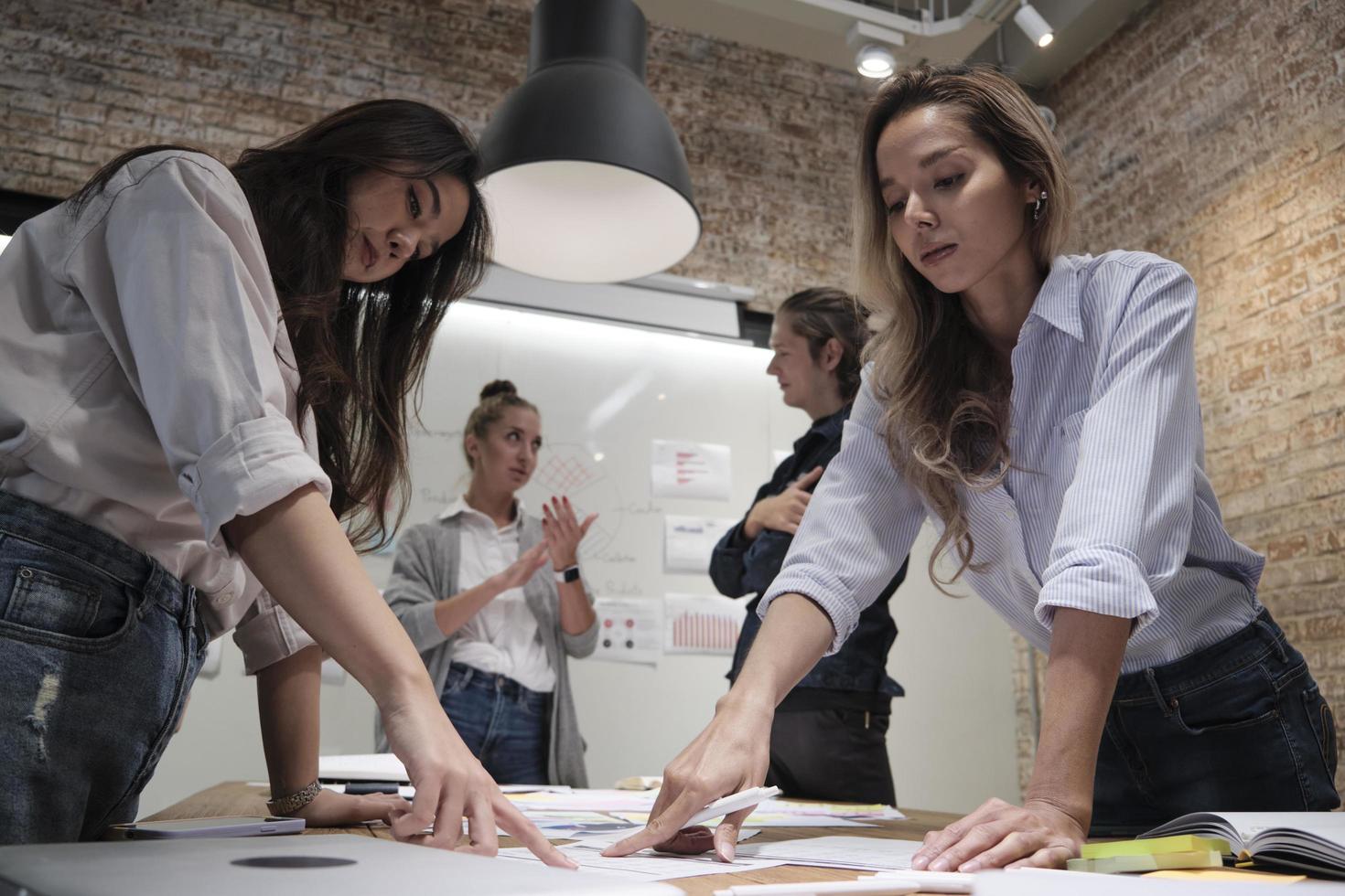 The coworkers' team and colleague brainstormed, discussing a marketing strategy, ideas collaboration, and business project planning at an office's conference table in the staff meeting workplace. photo