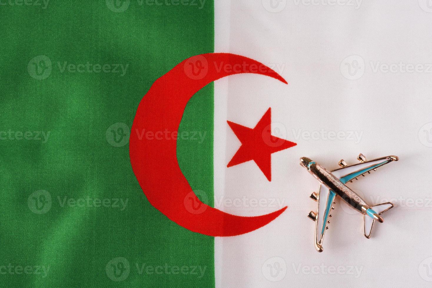 Plane over the flag of Algeria travel concept. photo