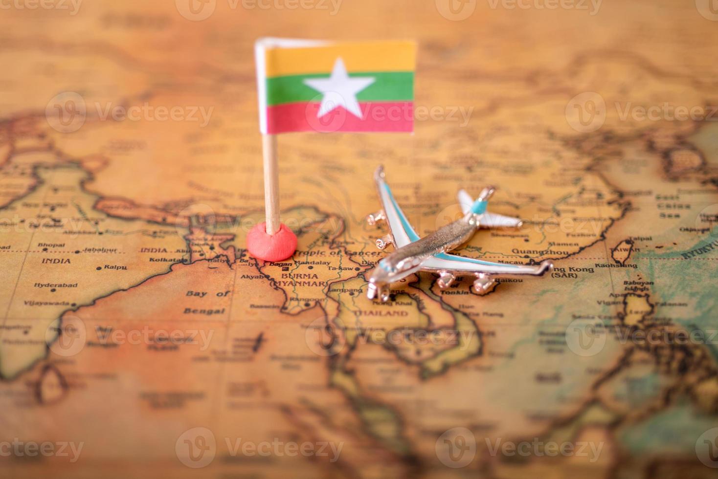 Myanmar flag and airplane on the world map. photo