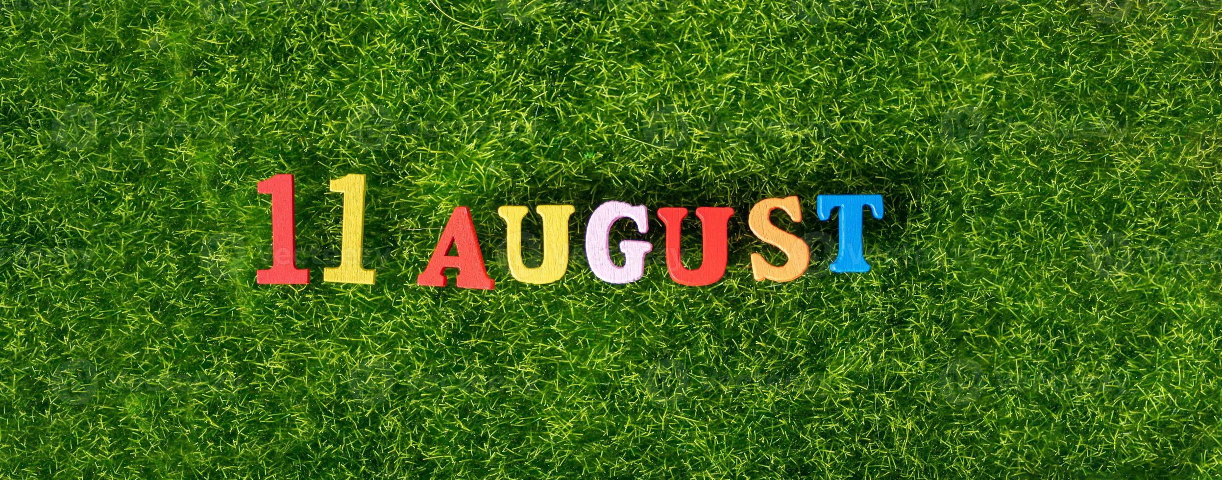 August 11. Image of wooden colored letters and numbers on August 11 against the background of a green lawn, mountain day in Japan. Summer day. photo