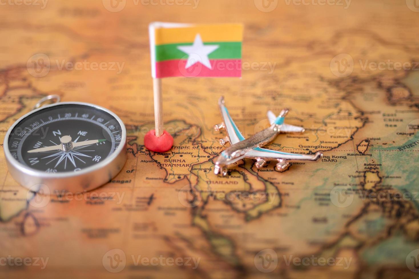 Myanmar flag, airplane and compass on the world map. photo