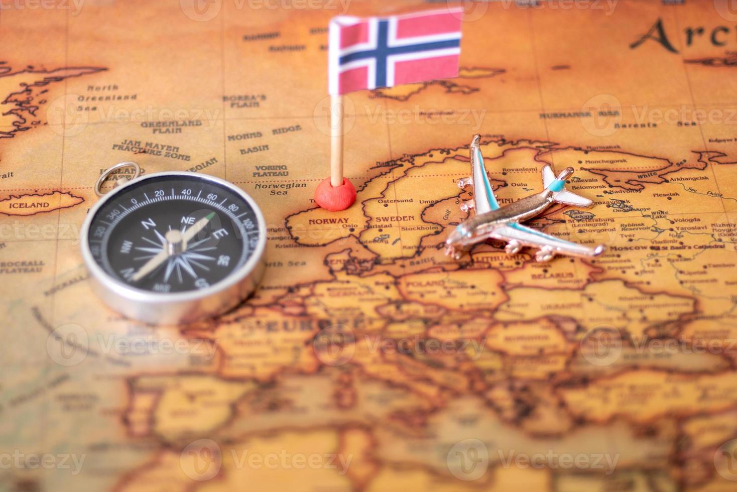 Norwegian flag, compass and airplane on the world map. photo