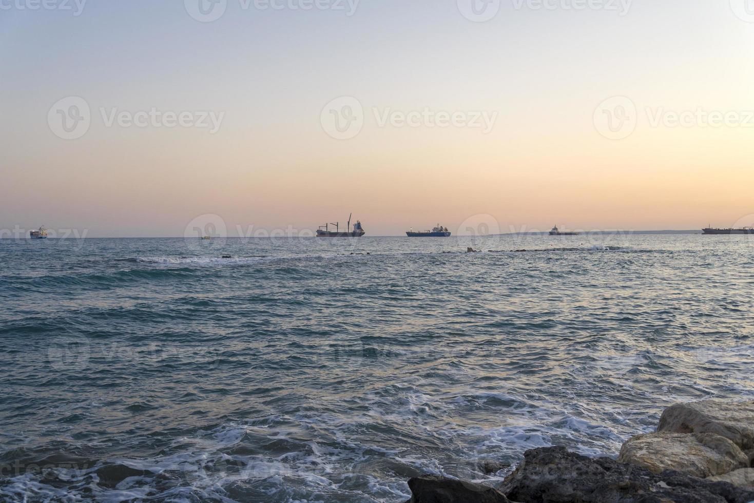 Cargo ships on the horizon of the Mediterranean sea. photo