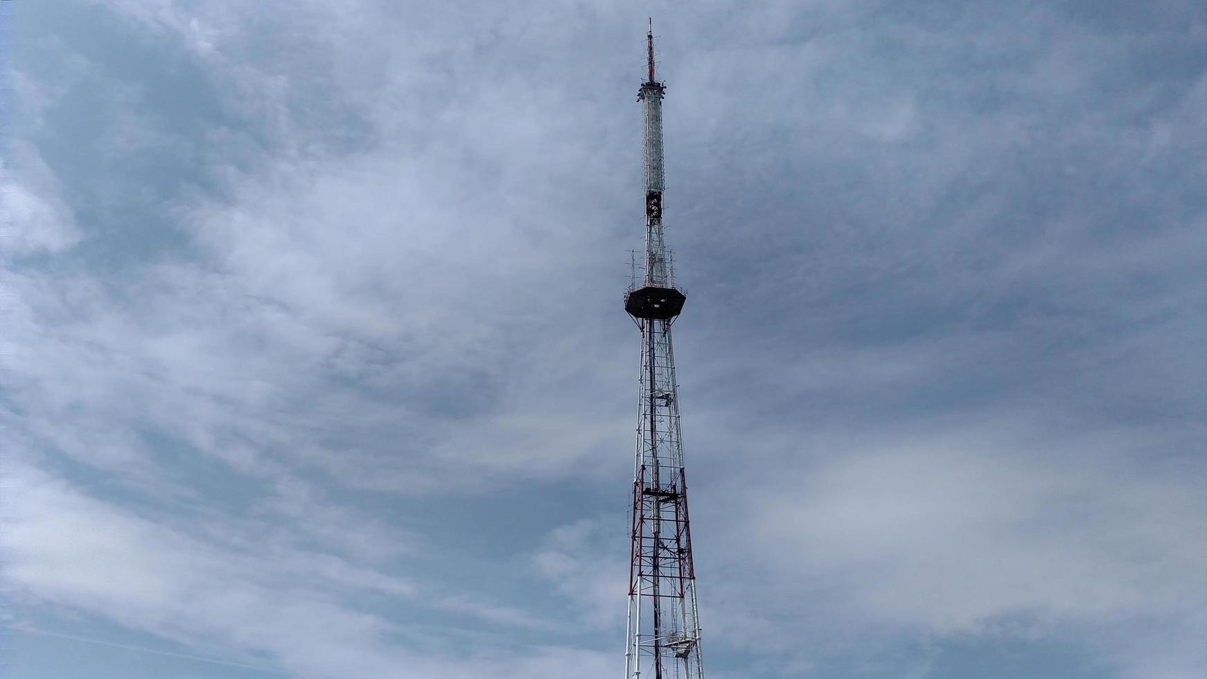 Telecommunication tower blue clouds on blue sky background photo