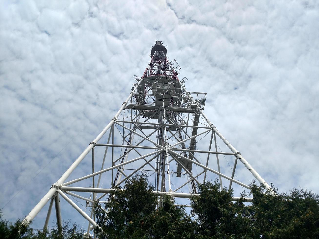 vista de arriba hacia abajo del botón de descripción general de la torre de telecomunicaciones en construcción con cielo de abajo hacia arriba con nubes blancas foto