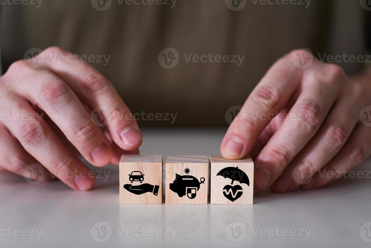 Close-up hand choose cube wooden toy blocks with insurance icon for safety family and health insurance. photo