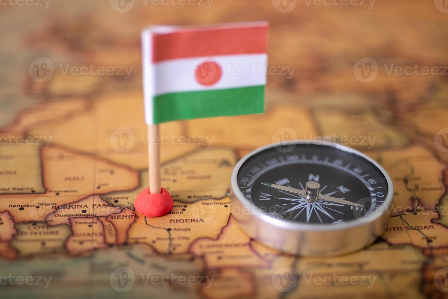 Niger flag and compass on the world map. photo