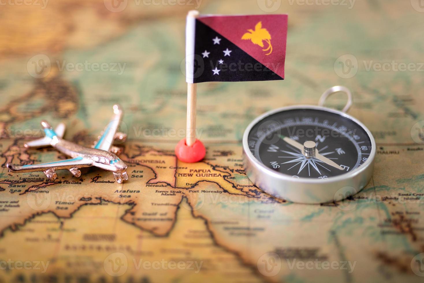 flag of Papua New Guinea, compass and airplane on the world map. photo