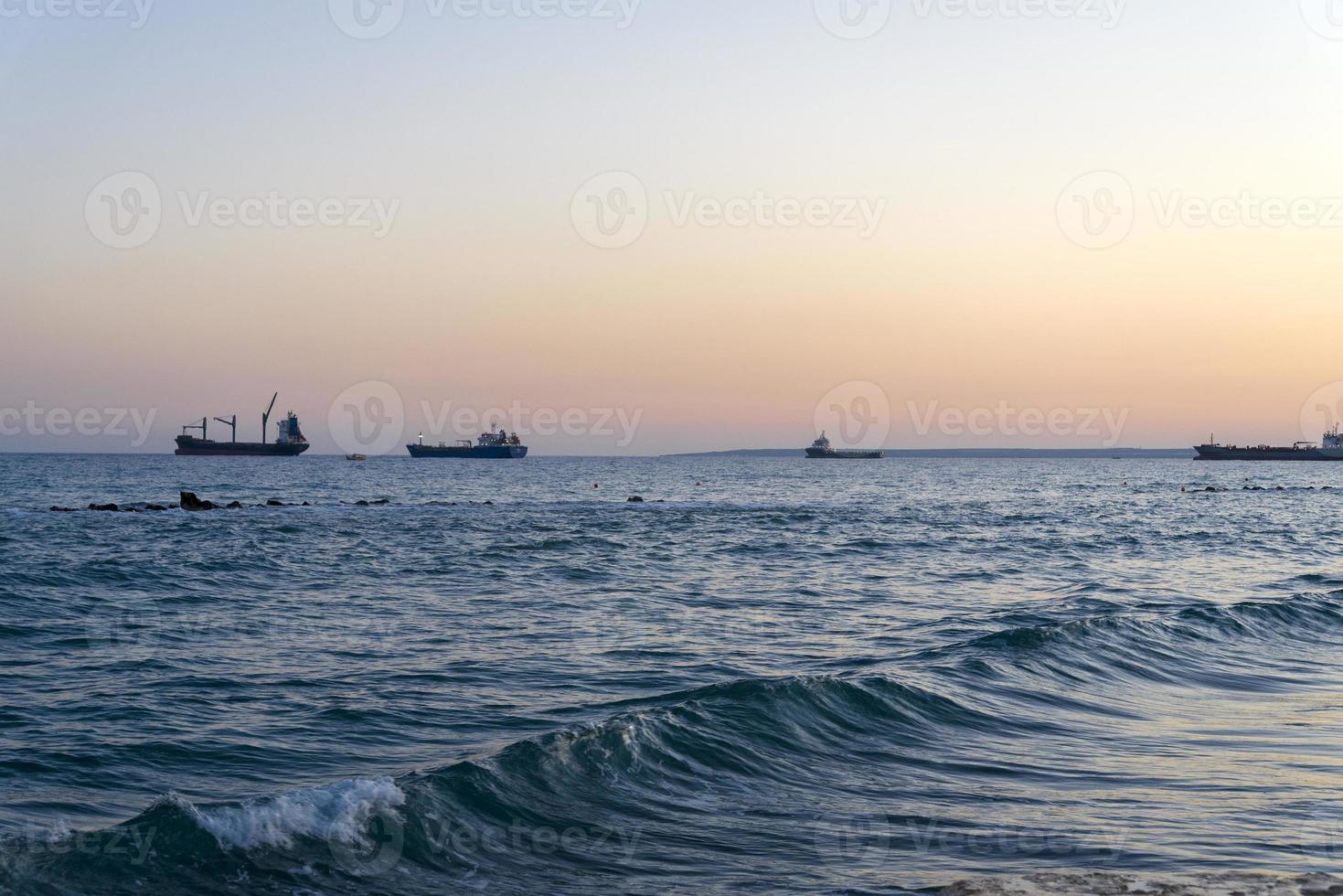 Cargo ships on the horizon of the Mediterranean sea. photo