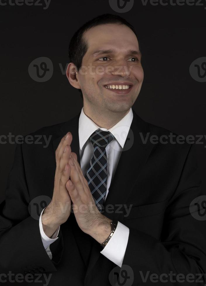 A man in a black suit on a black background. photo
