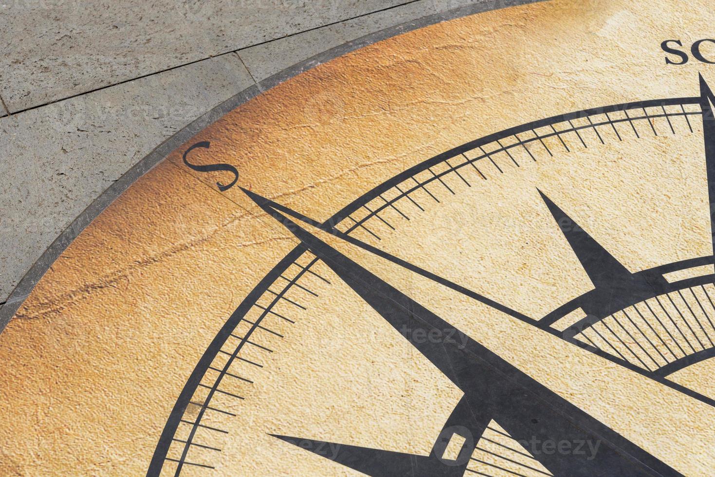 The compass is drawn on a concrete slab. photo