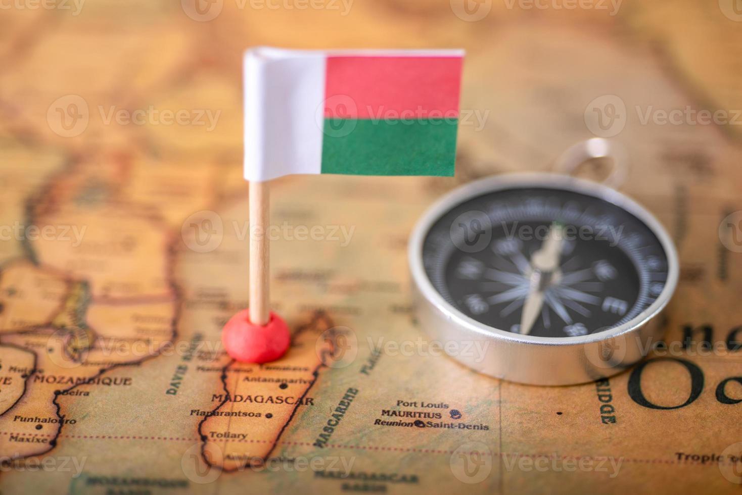 Flag of Madagascar and compass on the world map. photo