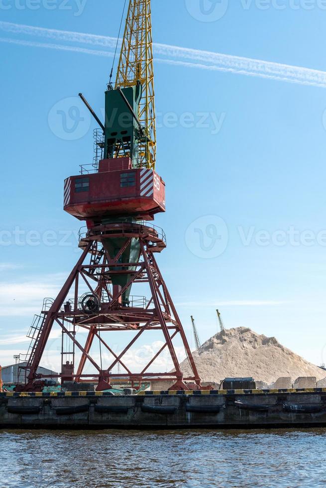 Many tall cargo cranes stand on the banks of the Venta River. Ventspils, Latvia, Baltic Sea. photo