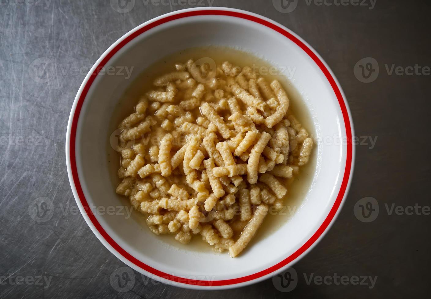 Homemade Italian Passatelli. Traditional Italian pasta cooked in broth. View from above. Bologna, Italy. photo