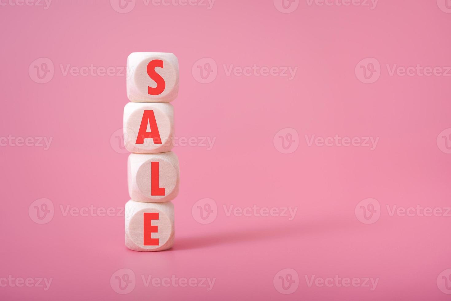 venta de palabras en cubos de madera, fondo rosa, lugar para texto. foto