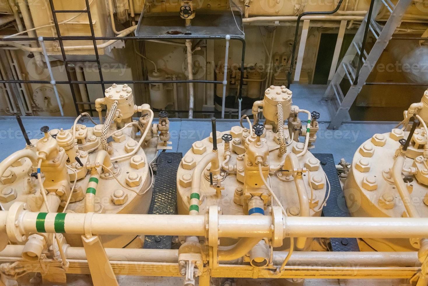 Yellow engine mounted on ship. Engine room on a old cargo boat ship. photo