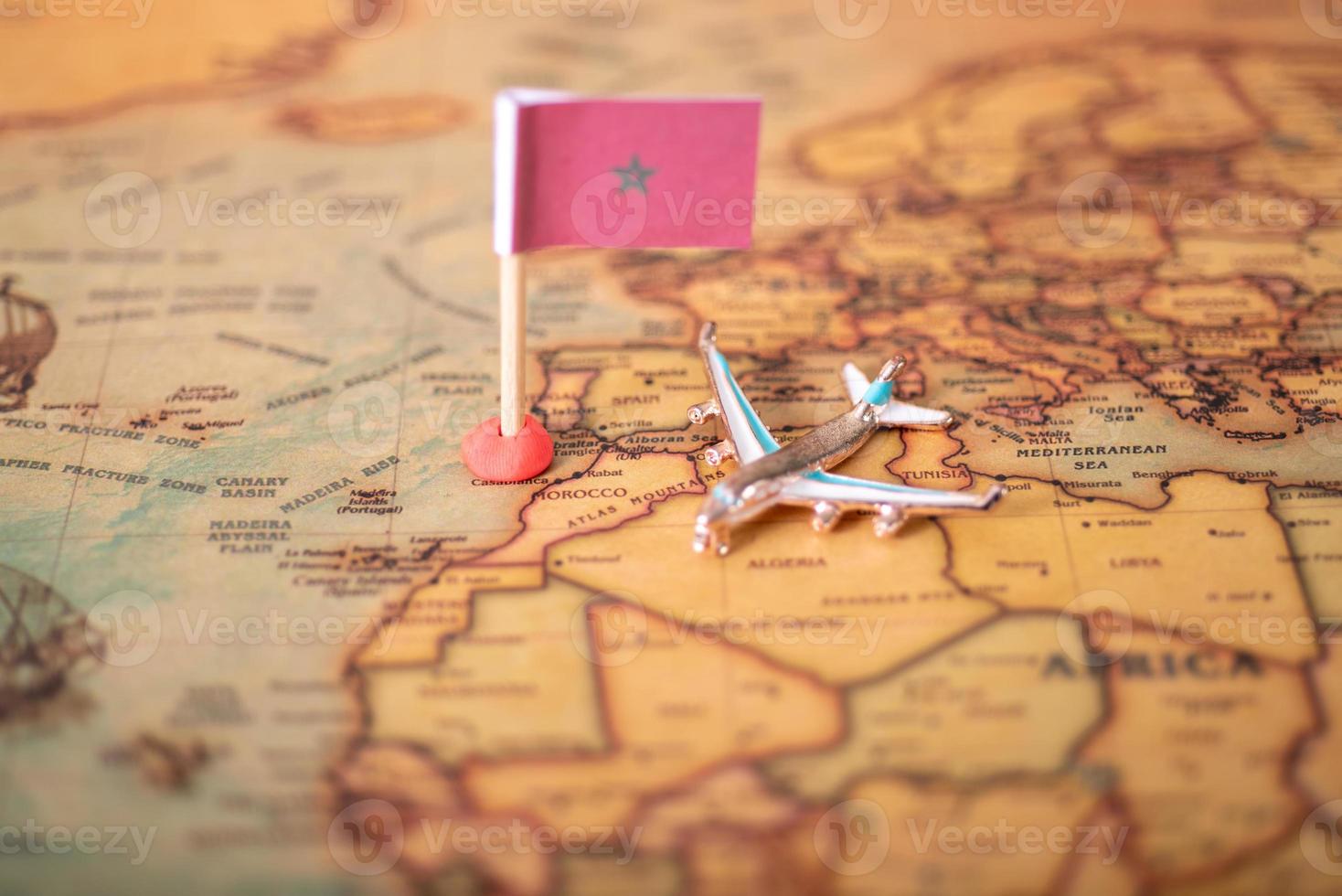 The flag of Morocco and the plane on the world map. photo
