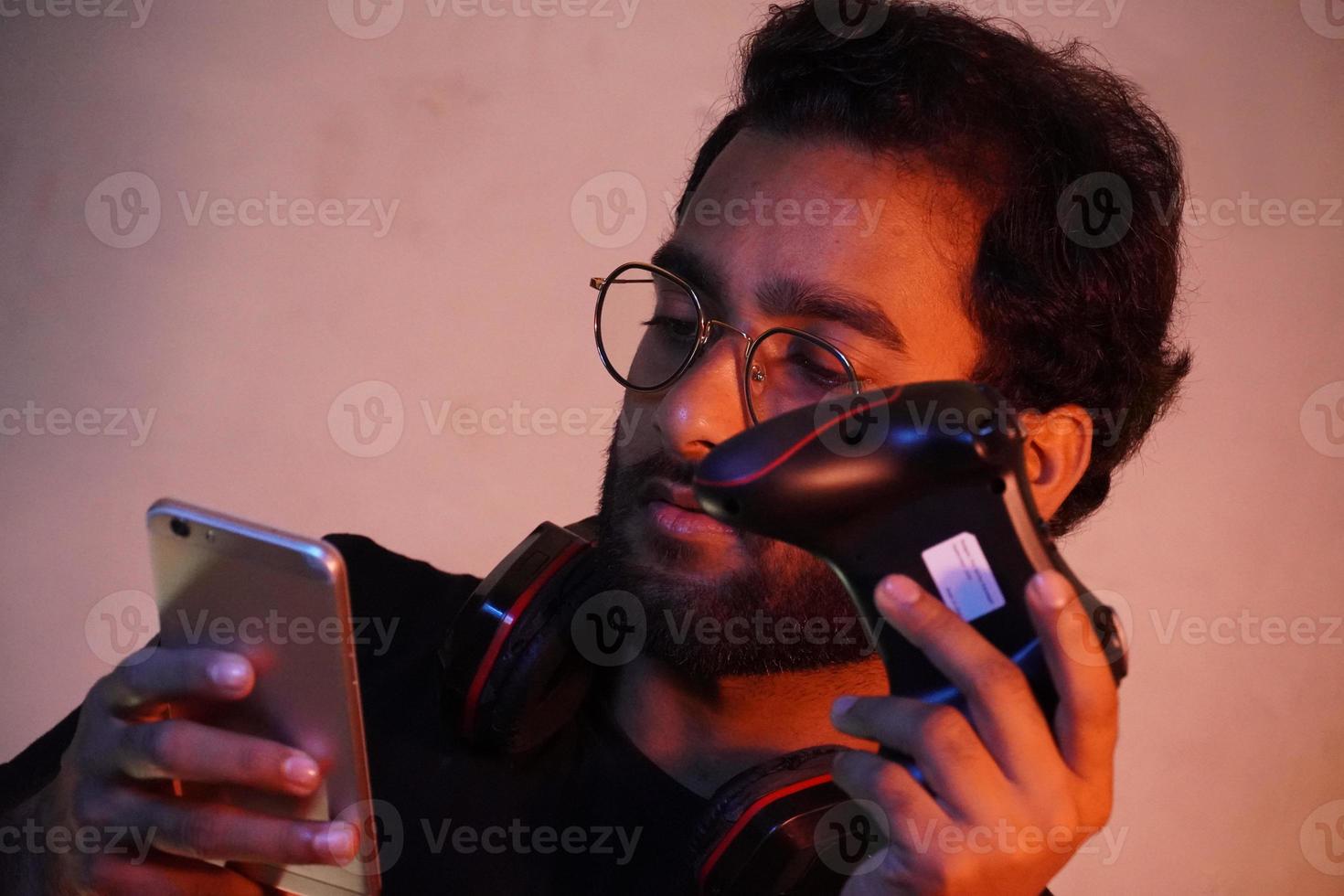 man using mobile and have gaming wireless joystick photo