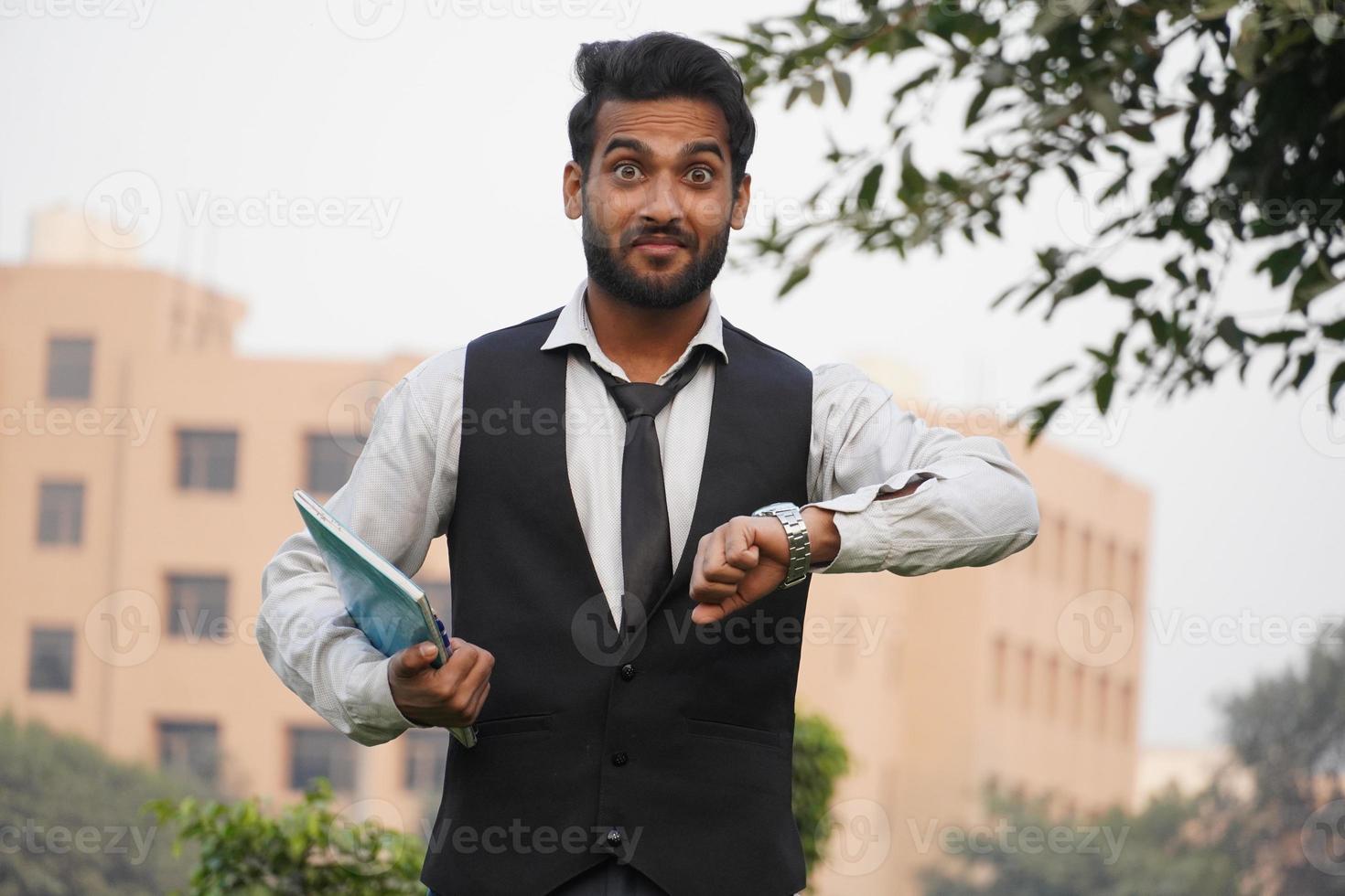 Handsome man wearing business clothes and looking at the watch time worried, afraid of getting late photo