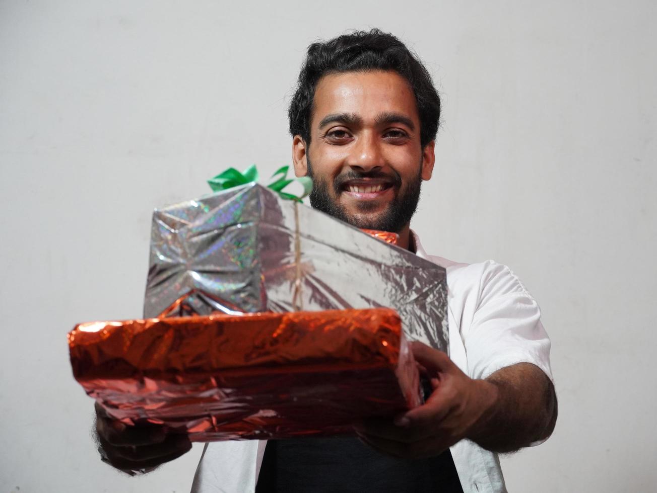 Young Man giving Stack of festival gifts Presents indoor photo