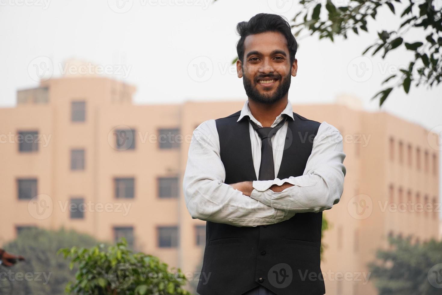 retrato de un hombre alegre y positivo que cruza la mano y se siente como un verdadero líder aislado sobre un hermoso fondo foto