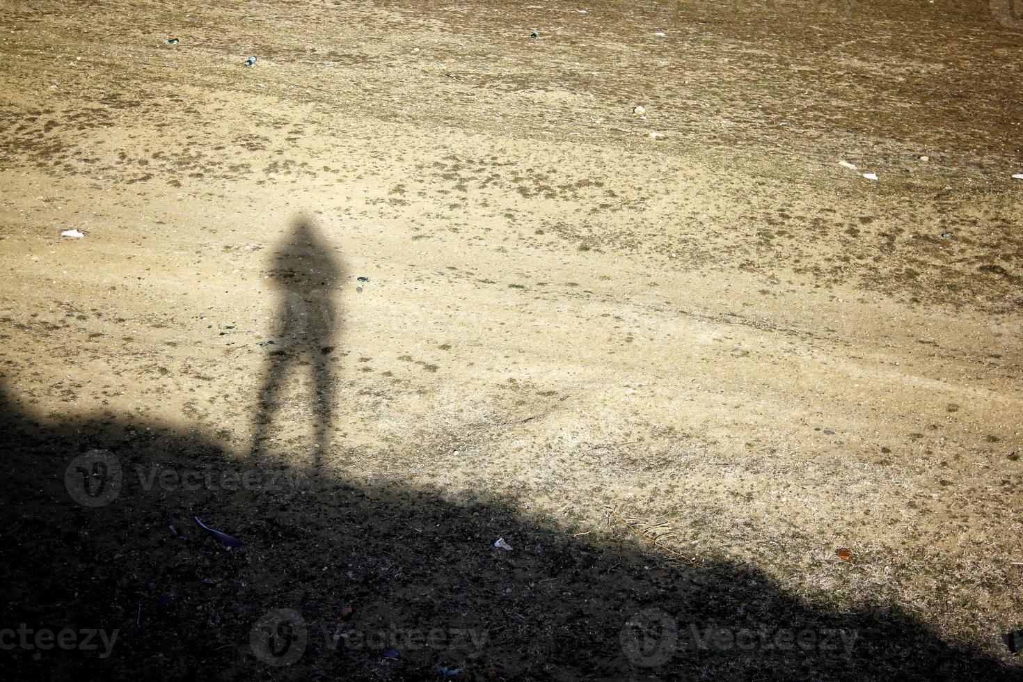 sombra solitaria de un hombre parado en la colina. sombra humana en el suelo. foto