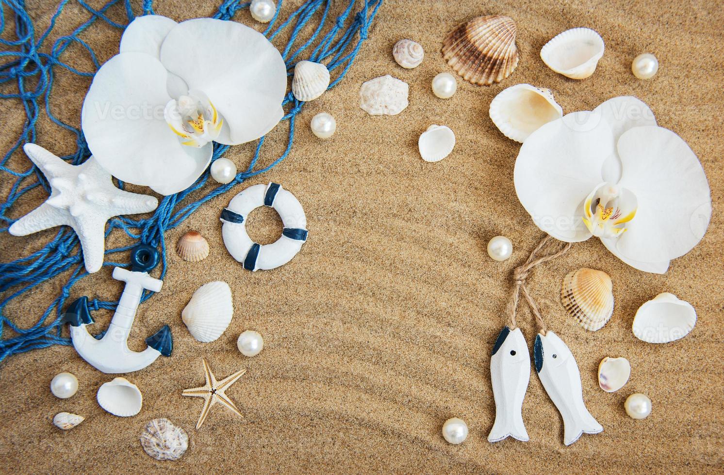 sea shells with sand and orchid flowers photo