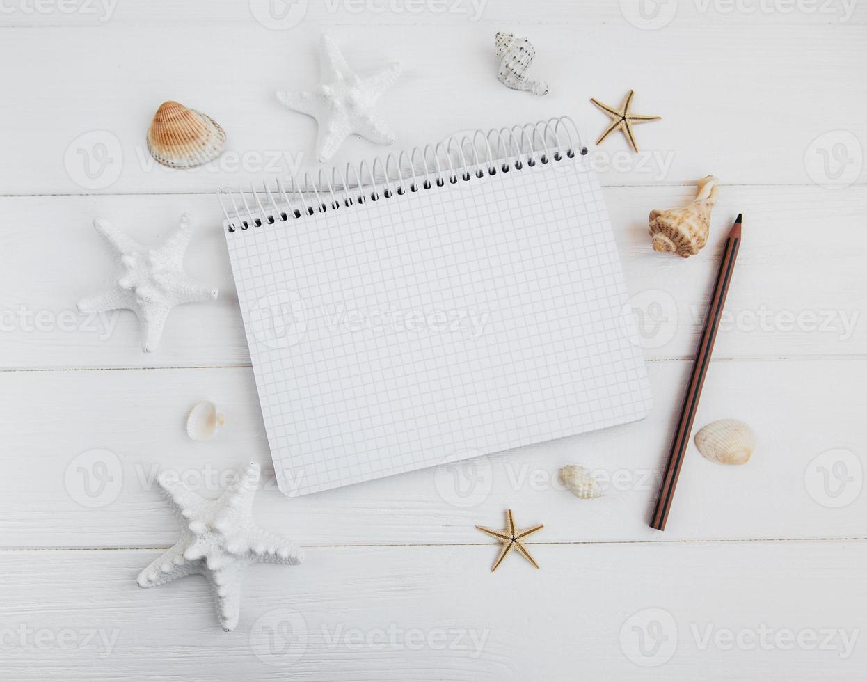 Shells and notepad on wooden table photo