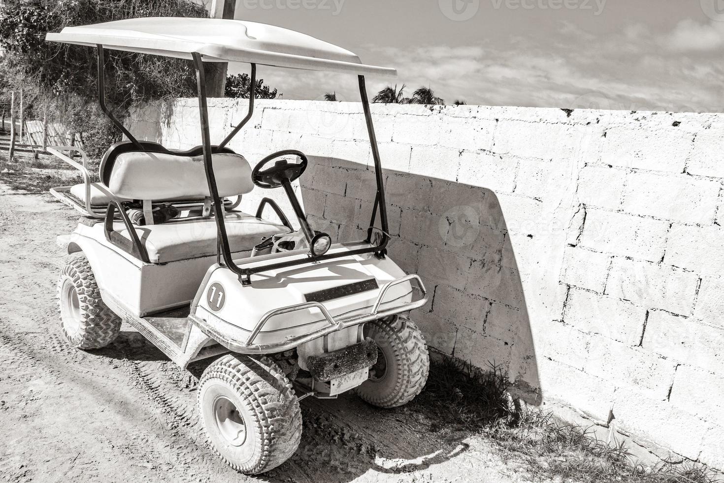 Golf cart buggy cars carts muddy street village Holbox Mexico. photo