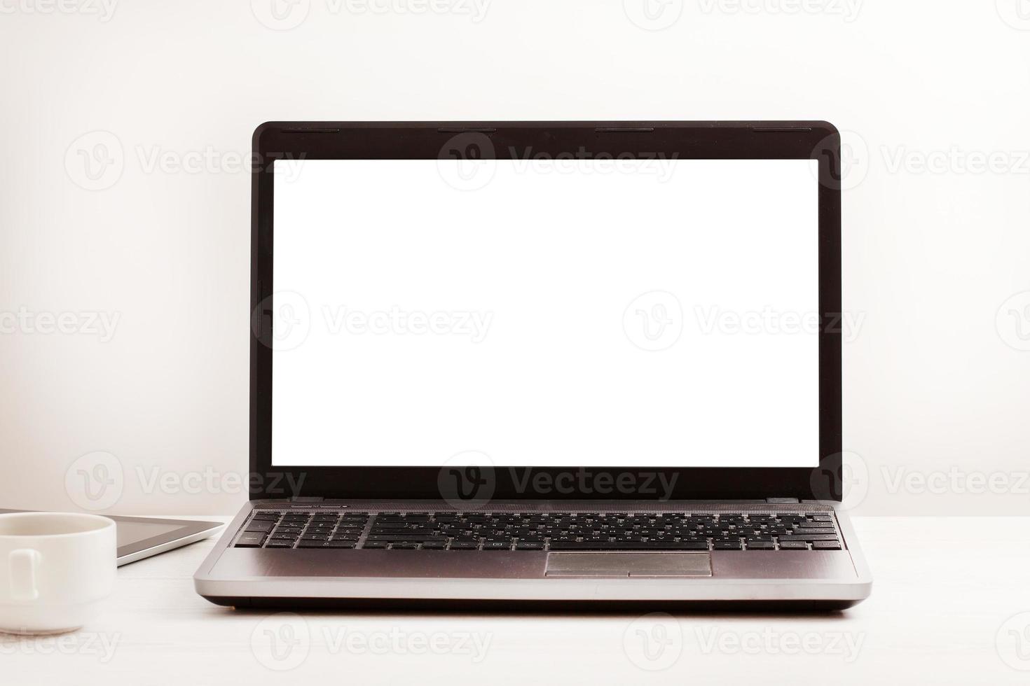 Laptop with blank screen on workplace. Empty space desk white office Interior. Copy space. Business concept. photo