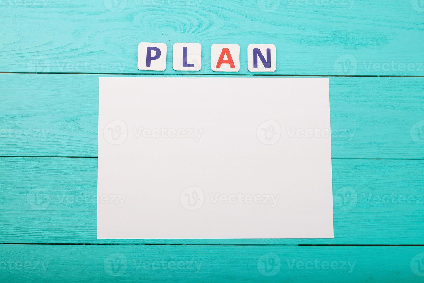 Word plan on blue wooden background. Top view photo