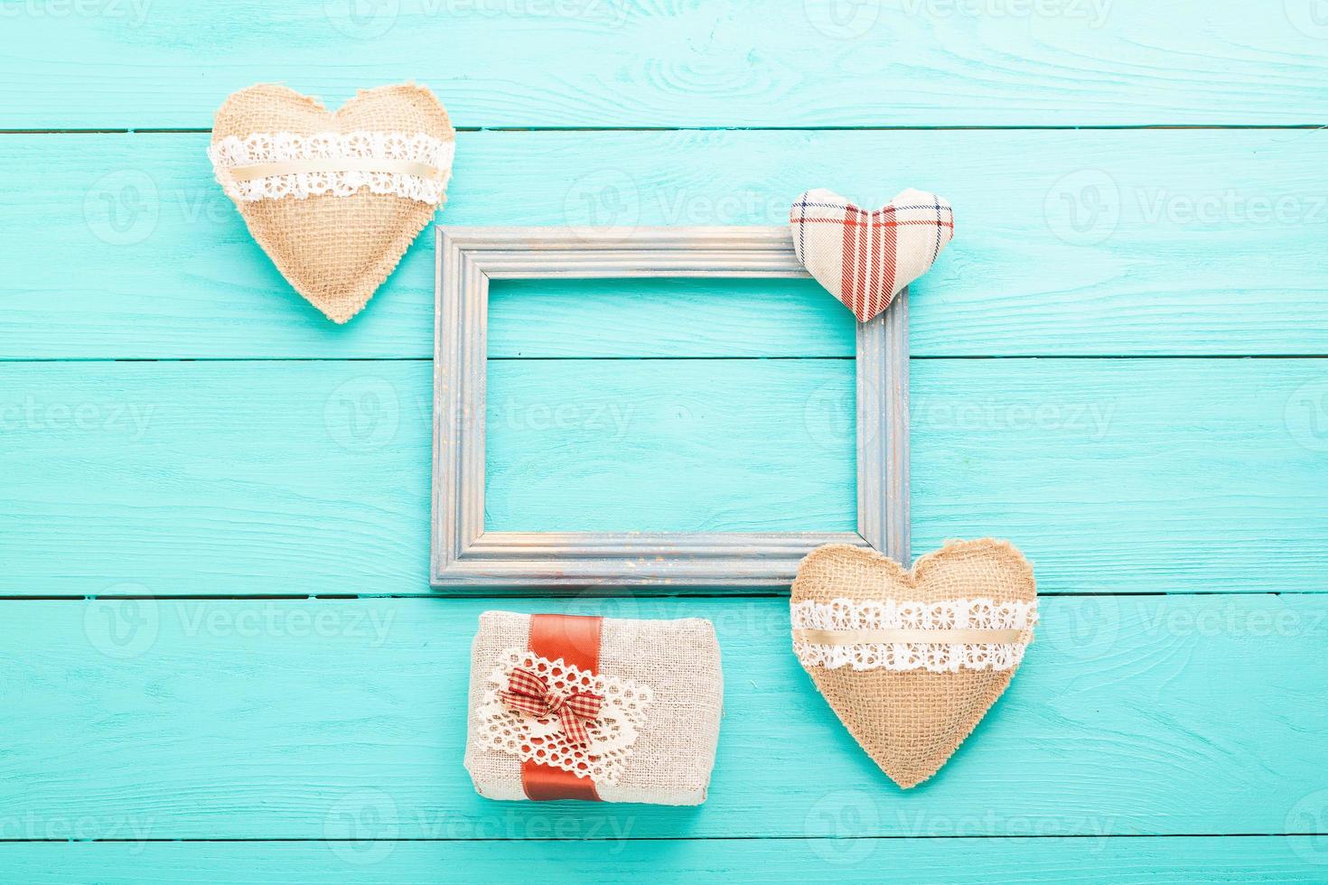 Romantic frame with copy space and accessories on blue wooden background. Top view photo