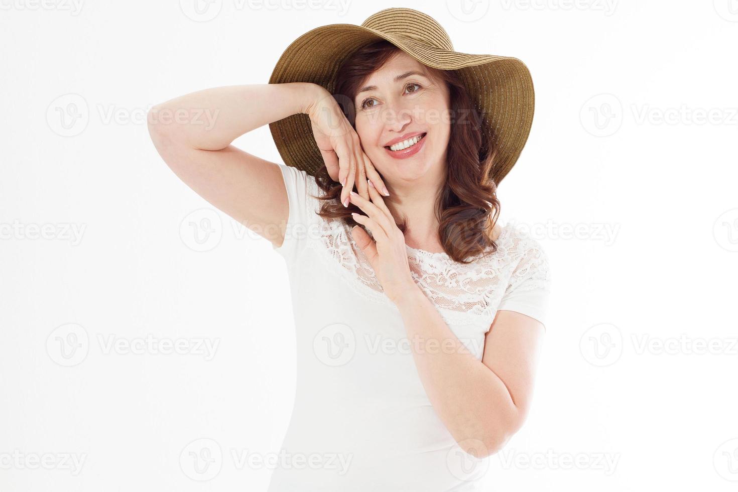 mujer feliz en sombrero de verano aislado sobre fondo blanco. protección solar, cuidado de la piel y concepto de vacaciones. mujer de mediana edad con dientes blancos sanos y menopausia. viaje de vacaciones. copie el espacio foto