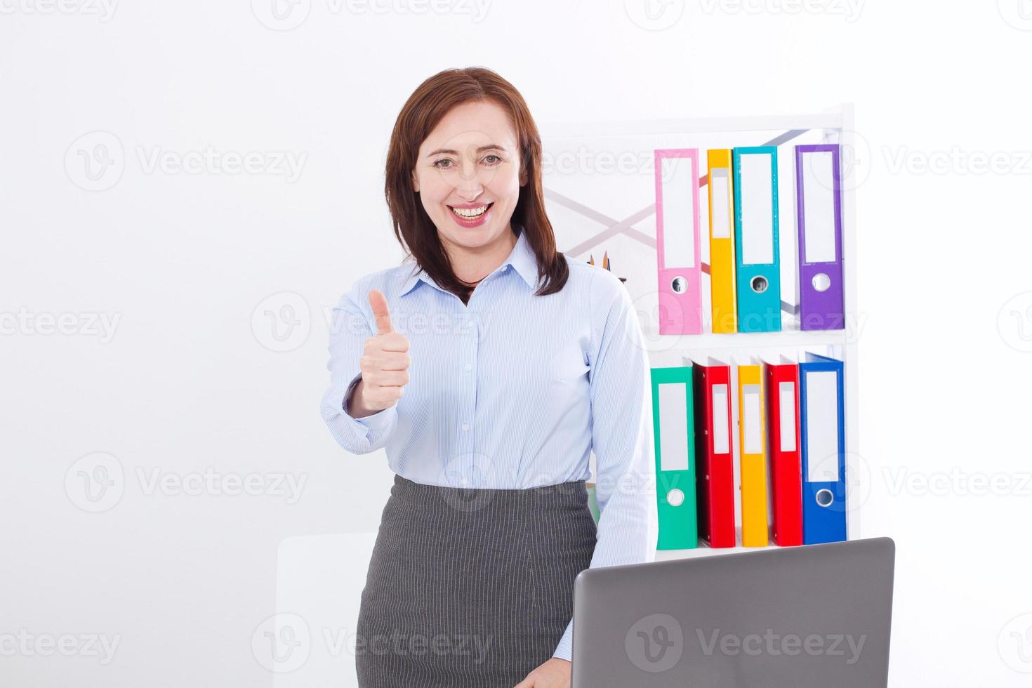 Smiling Businesswoman and big thumb up isolated on white background at office. Business success concept. Woman at work photo