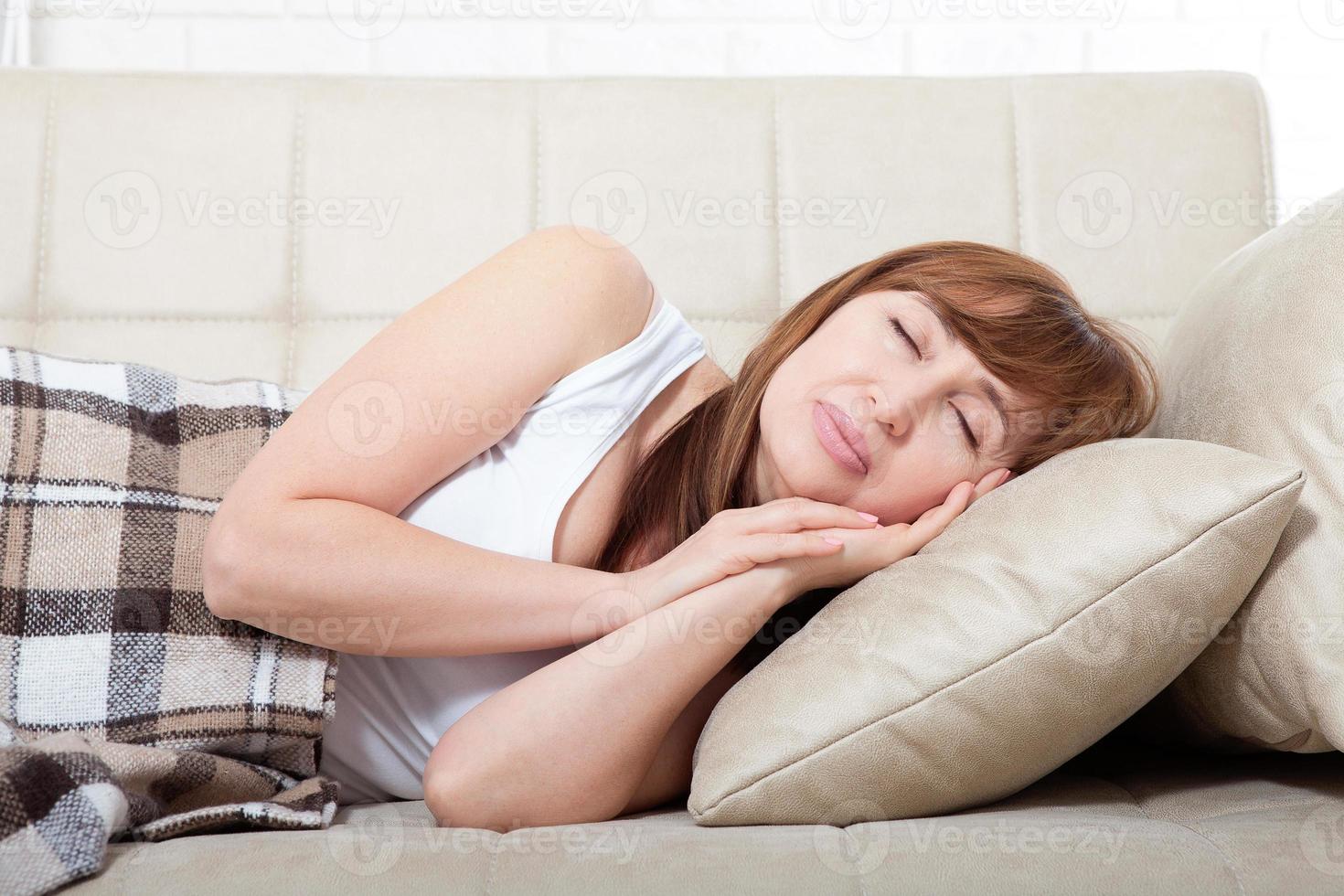 Daytime sleep. Middle age woman sleeping on bed in modern apartment. Home background. Copy space and mock up. Menopause photo