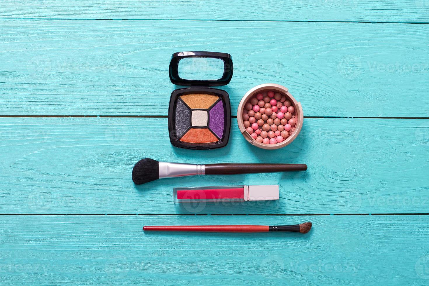 Cosmetics and accessories on blue wooden background. Top view photo